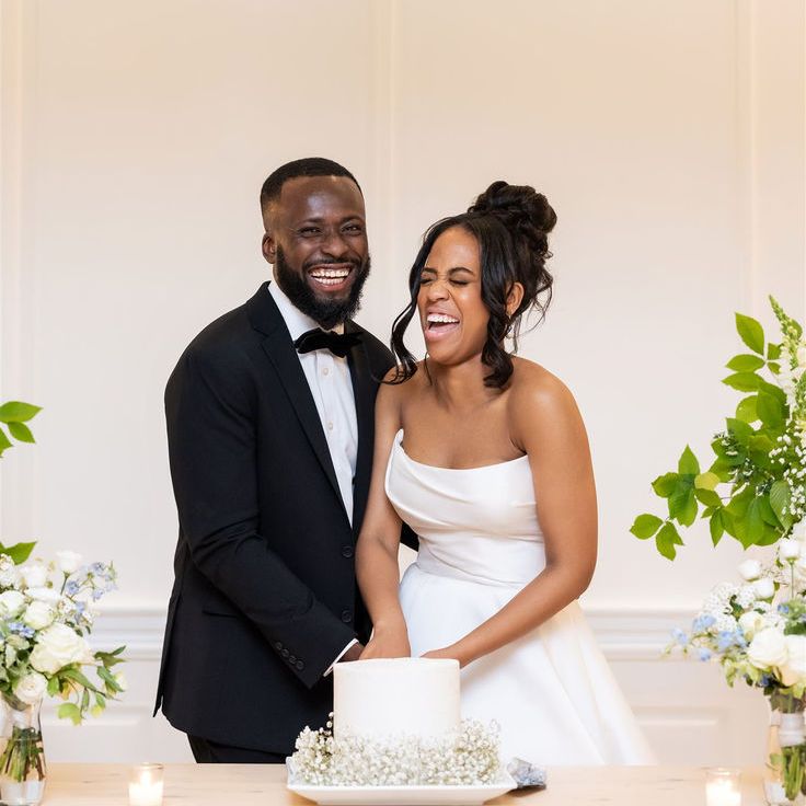 Bride & Groom Laughing As They Cut The Wedding Cake