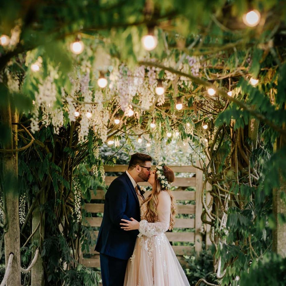 Couple kisses under canopy at barn wedding 