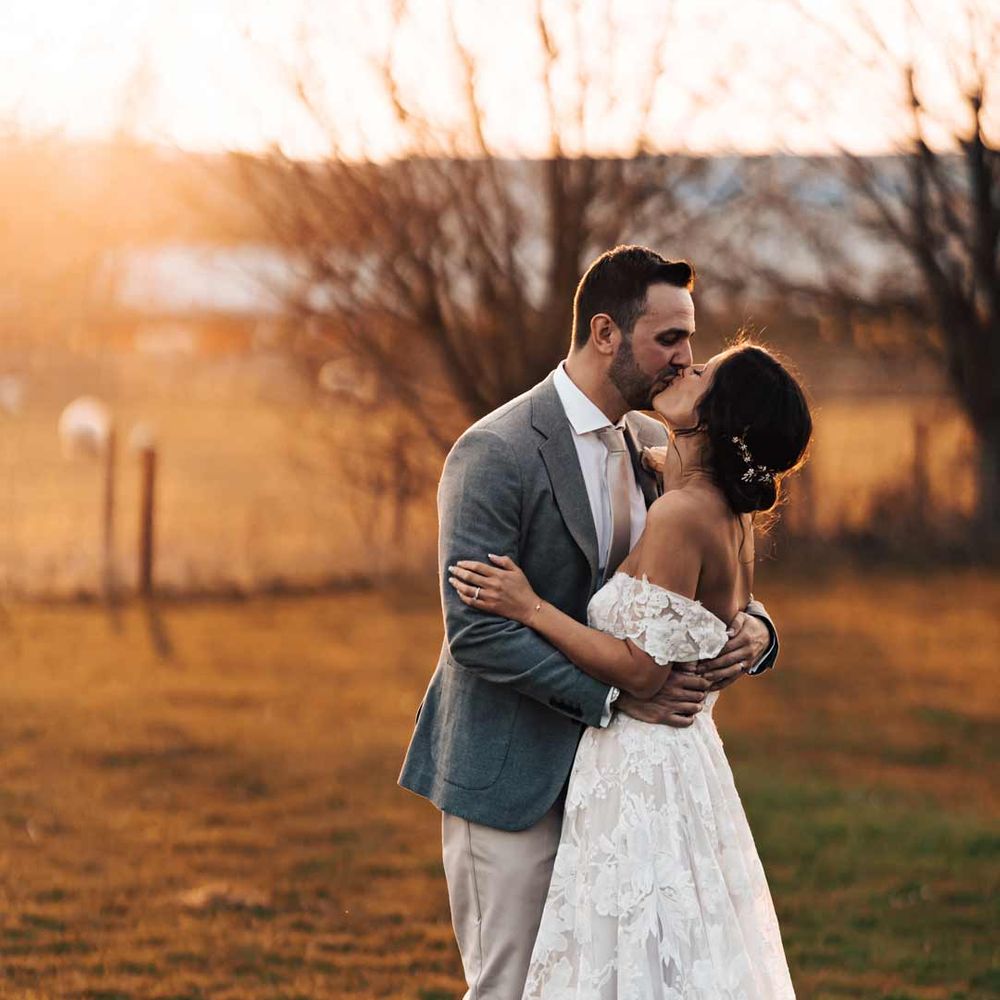 Couple leans in for a kiss at barn wedding 