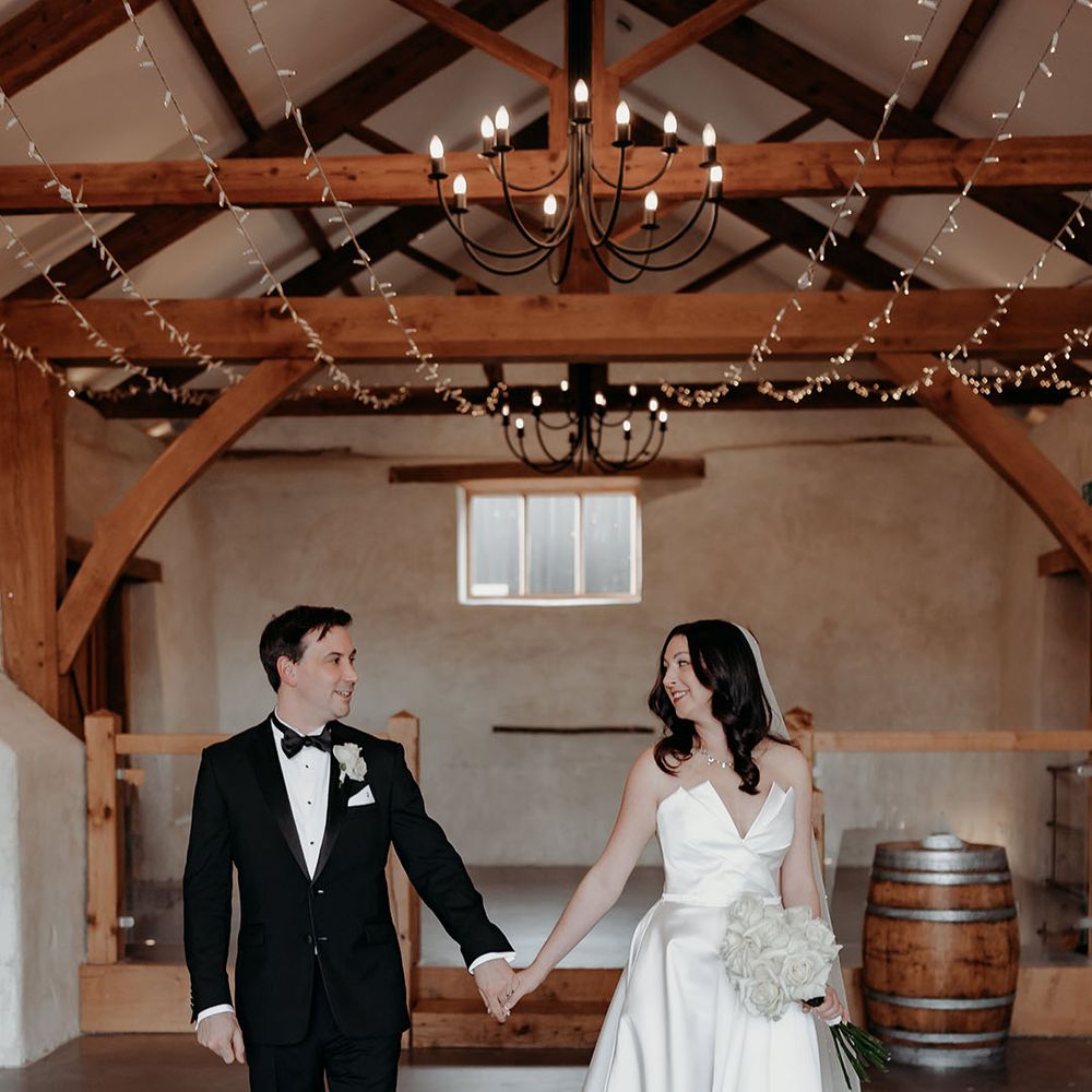 Couple holding hands at their barn wedding 