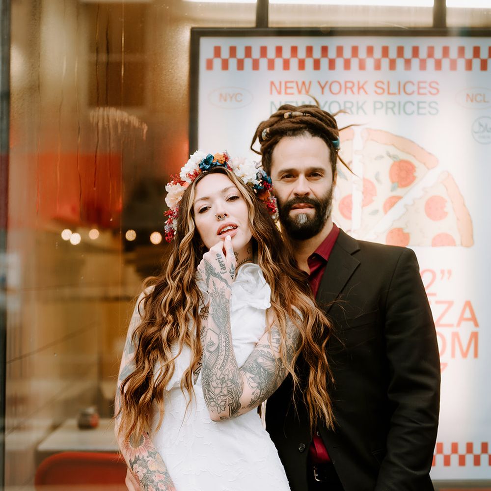Alternative modern fashion for bride and groom with bride carrying autumnal dried wedding bouquet