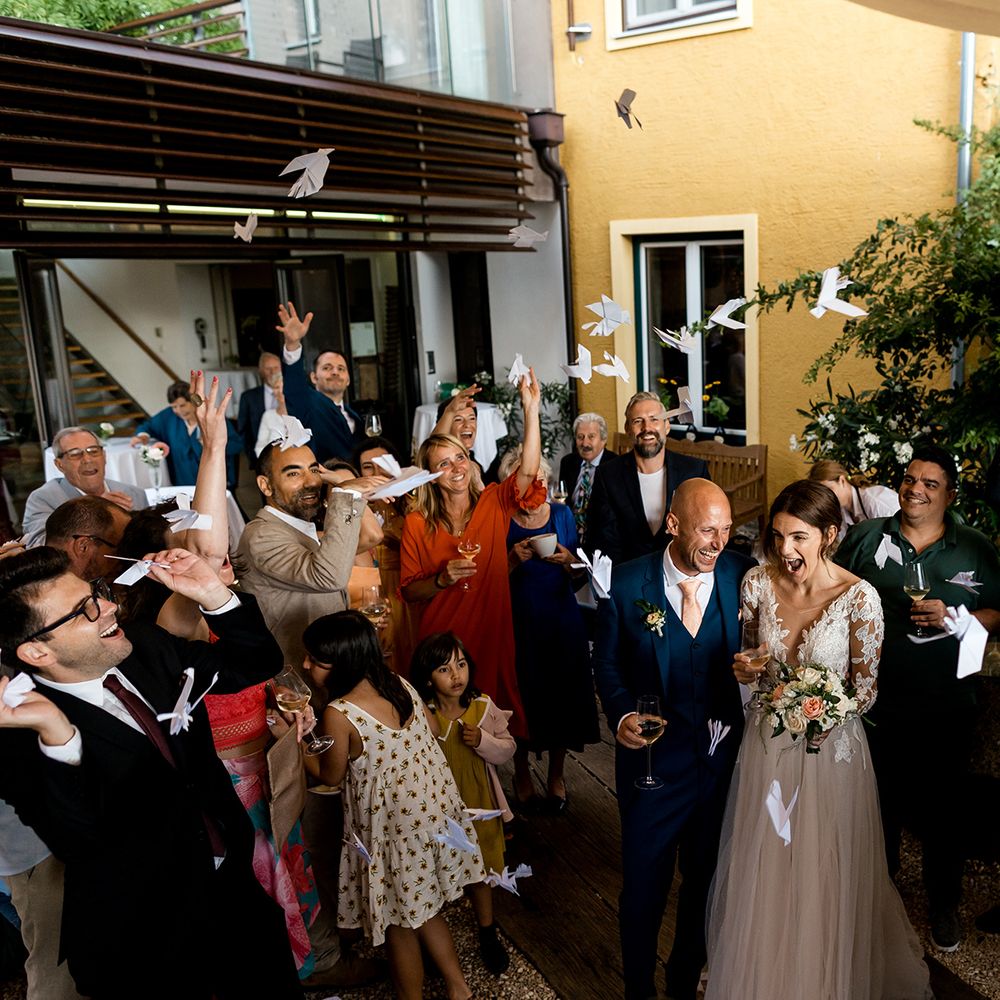 married couple showered with paper planes 