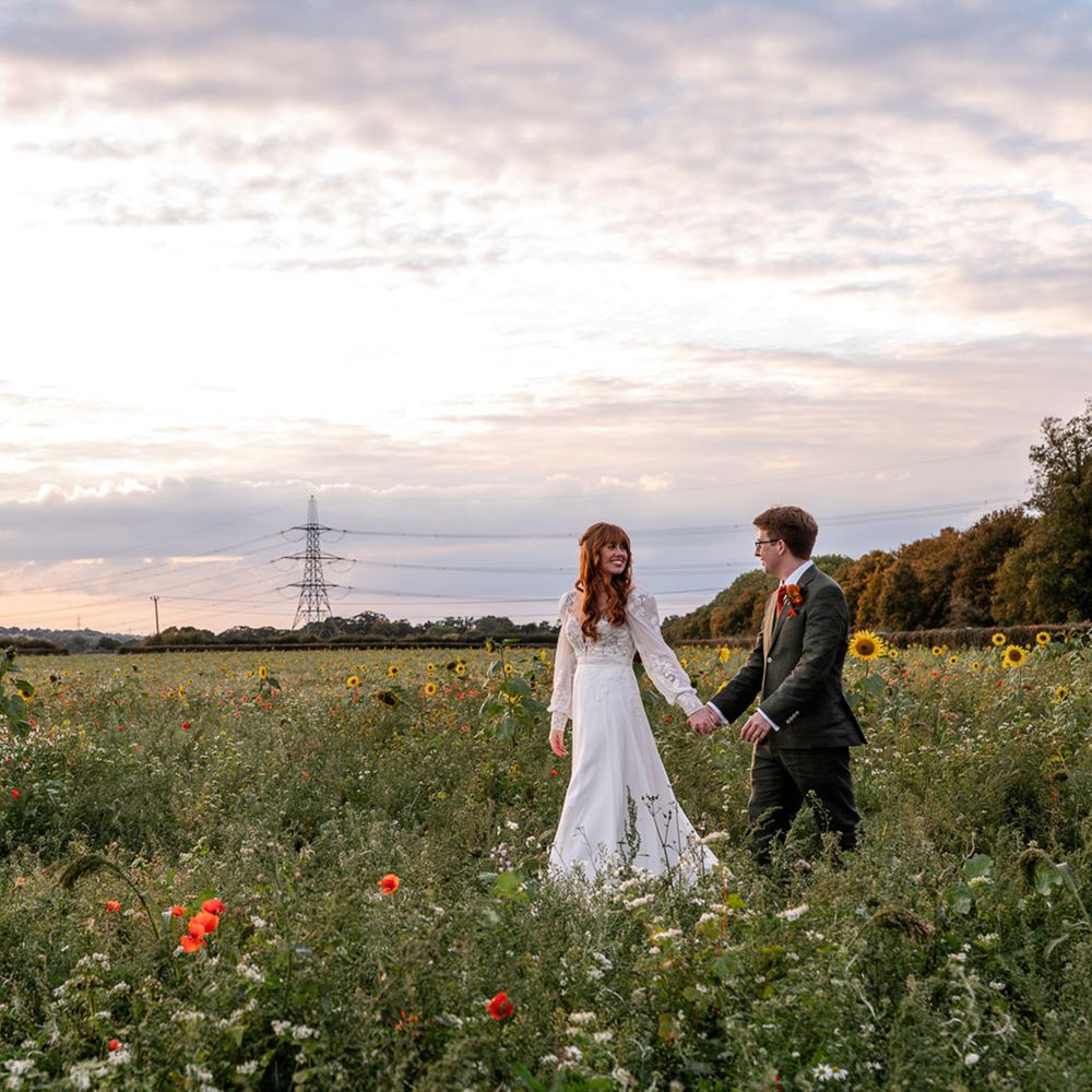 The Barns at Redcoats flower field bride and groom walking