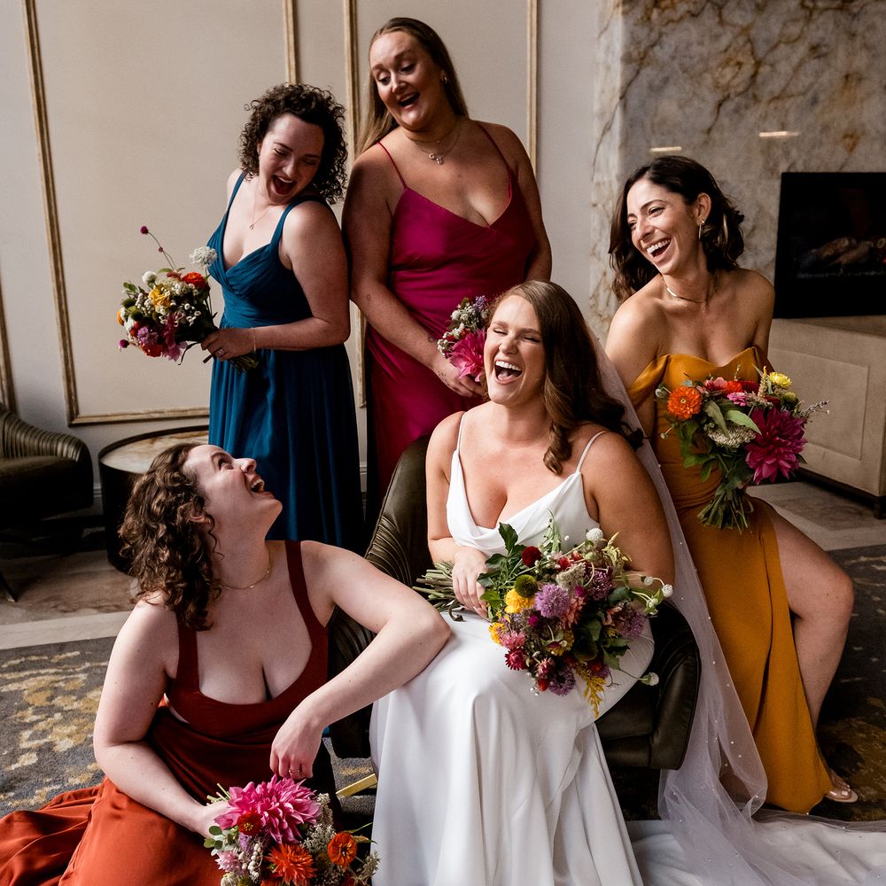 bride laughing with bridesmaids in winter colourful dresses