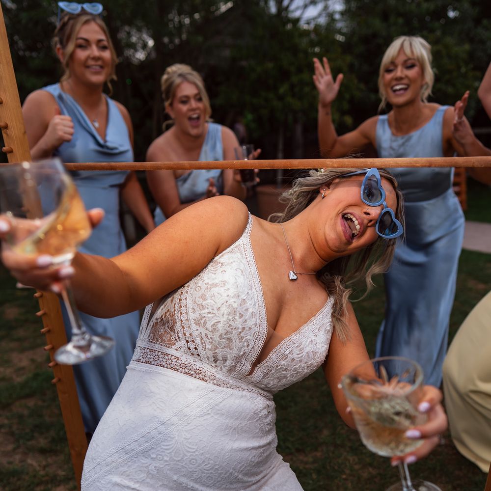bride limbo wine glasses in hand