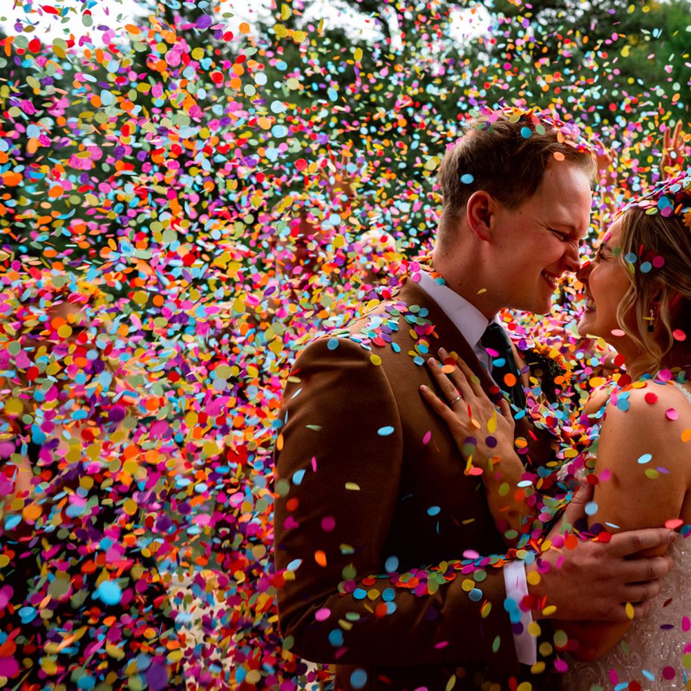 colourful rainbow confetti covered bride and groom