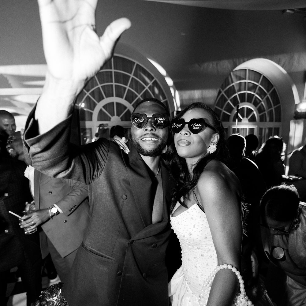 Bride and groom in personalised heart sunglasses celebrating together on the dance floor