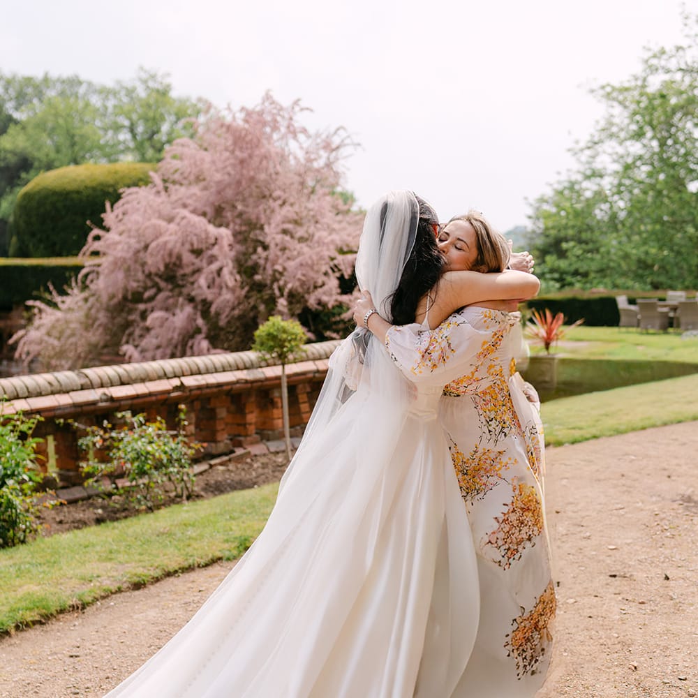 bride hugging floral dress guest