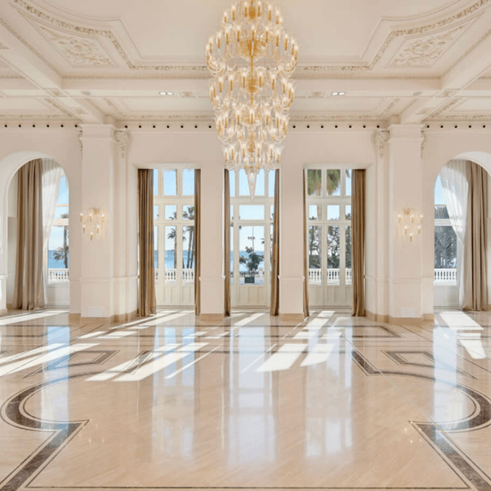 Gran Hotel Miramar wedding venue with grand ballroom with crystal chandelier, polished marble floor and arched windows overlooking the sea