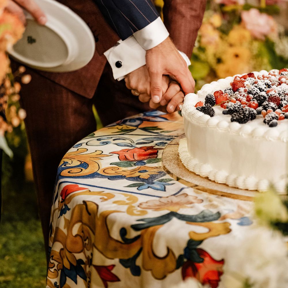 grooms cutting berry topped cake