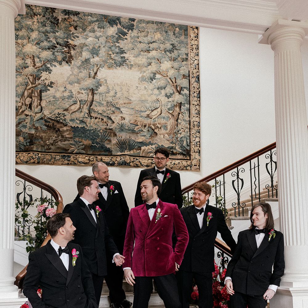 groomsmen black tuxedos laughing staircase
