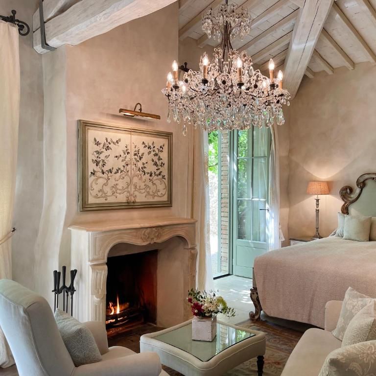 Elegant bedroom suite with crystal chandelier, carved fireplace and ornate upholstered headboard