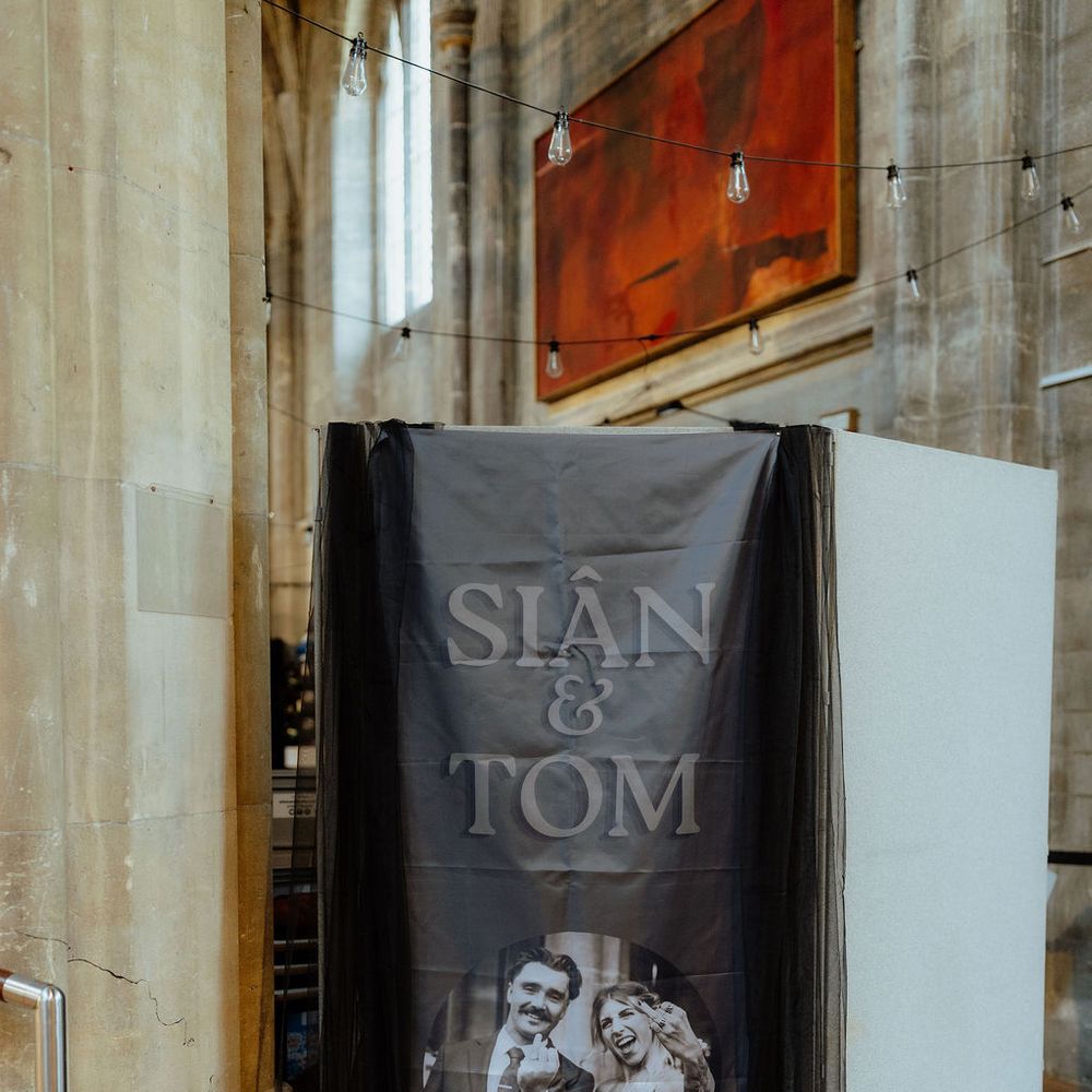 Personalised black wedding banner with couple's names and portrait draped in tulle