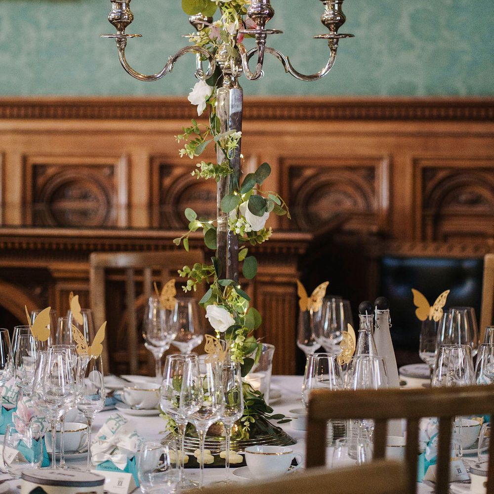 Silver candelabra centrepiece with white roses and eucalyptus on an elegant wedding table
