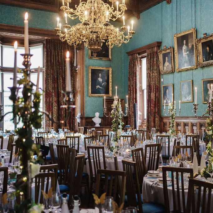 Grand stately home dining room set for a wedding with candelabra and gold-framed portraits