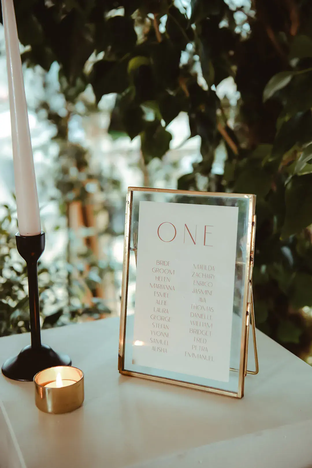 Gold photo frame with table plan made from compostable wedding stationery