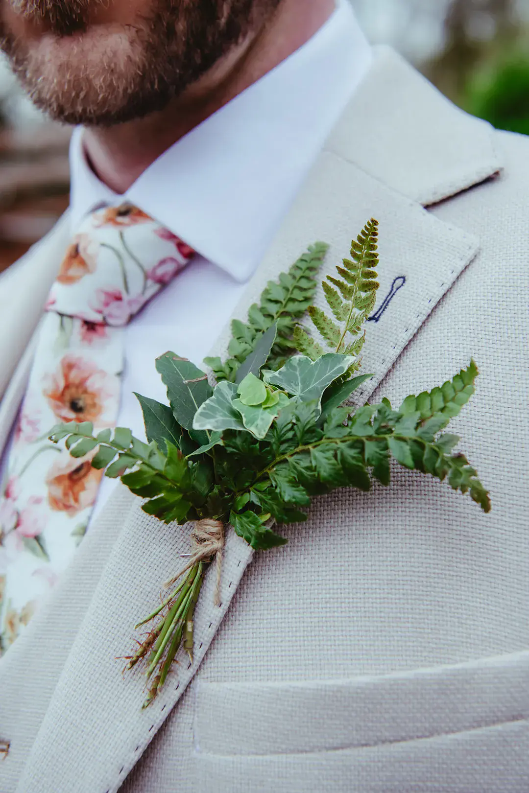 Foliage buttonhole groom's accessory with floral tie