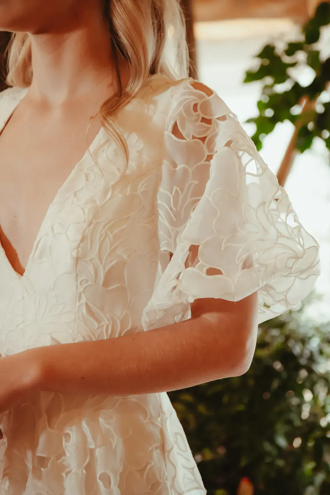 Floral lace detailing on the bride's short sleeve that matches the botanical wedding theme 