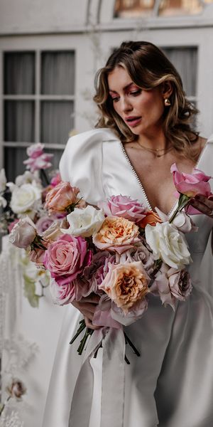 Bride holding a colourful pink and white rose wedding bouquets 