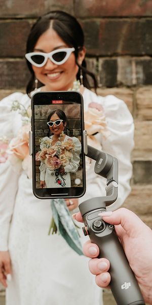 Wedding content creator filming bride with retro sunglasses on