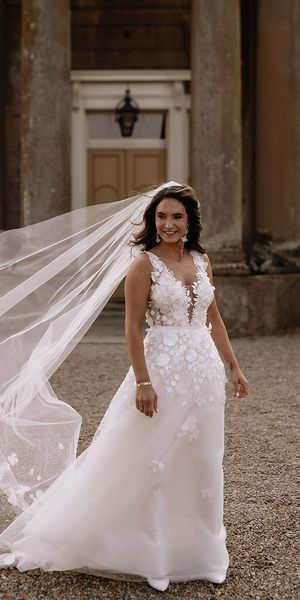 Bride in Mira Zwillinger appliqué wedding dress with floral embroidered veil. 