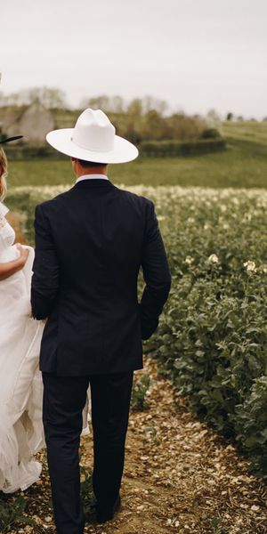 Country theme Stone Barn wedding with bride and groom wearing cowboy hats