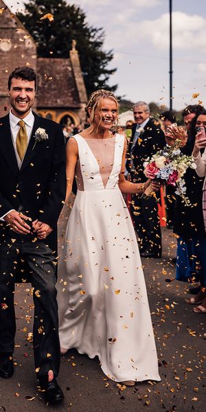 Bride walking with the groom out to confetti in a Andrea Hawkes wedding dress.