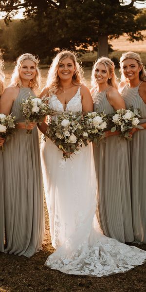 Bridesmaids in sage green pleated bridesmaid dress with the bride for a rustic barn wedding.