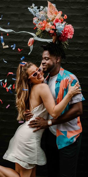 Fun East London elopement with fabric wedding banner, short wedding dress and colourful flowers 