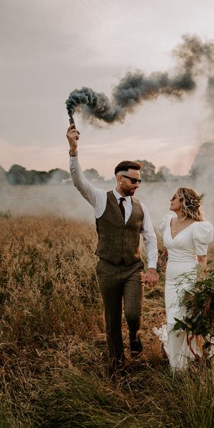 Willow Marsh Farm wedding with the bride and groom waving smoke bombs
