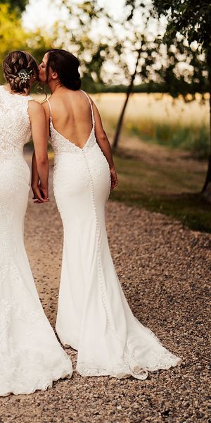 Brides in lace wedding dresses for outdoor summer wedding at Cripps Barn.
