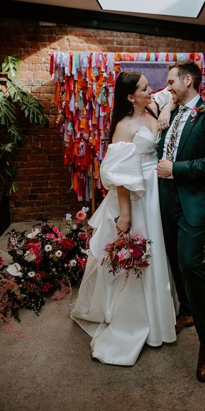DIY rainbow streamers altar decoration with bride and groom