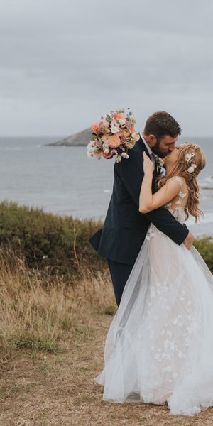 Bride in Anna Kara wedding dress kissing the groom at Devon wedding.