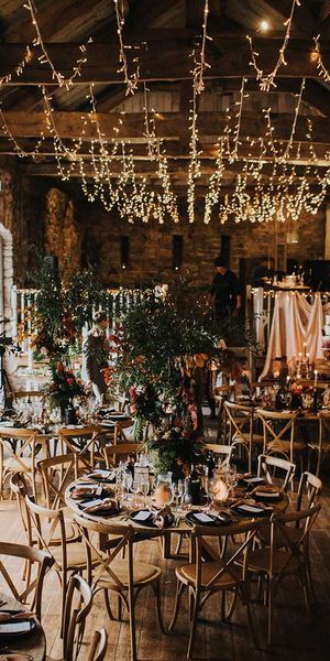 Autumn theme wedding at Askham Hall in cumbria with fairy lights and tree centrepieces 