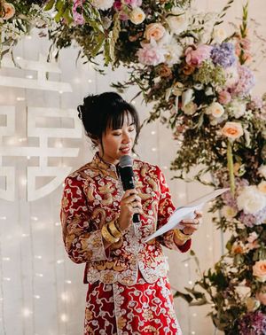 Bride in Chinese wedding attire reading out modern wedding reading