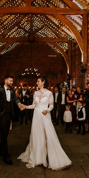 Bride and groom have their first dance with fairy-lights at rustic Hazel Gap Barn wedding venue. 
