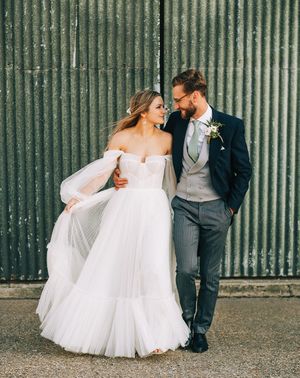 Bride in tulle wedding dress by Alena Leena Bridal with groom.