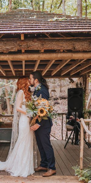 Outdoor forest wedding with sunflower wedding bouquet, embroidered veil and lace wedding dress.
