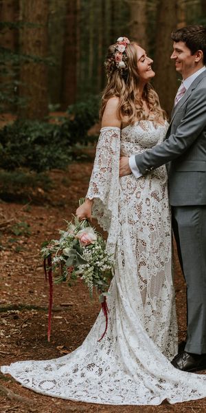 Bride in strapless lace medieval wedding dress with custom sleeves with groom in woodland after handfasting ceremony. 