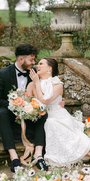 Romantic Holesfoot wedding inspiration with orange and white flowers, lace and beaded wedding dresses and an iced wedding cake