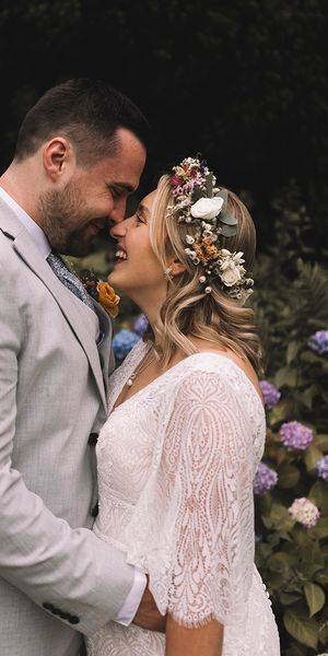 Bride wearing a wildflower wedding crown with groom at boho wedding.