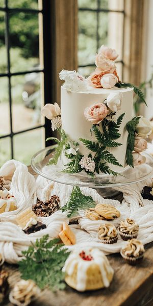 Vegan wedding inspiration with a dessert table and white iced wedding cake.
