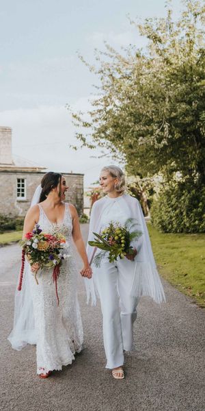 LGBTQI+ wedding with bride in handmade bridal jumpsuit with cape for five day long wedding adventure