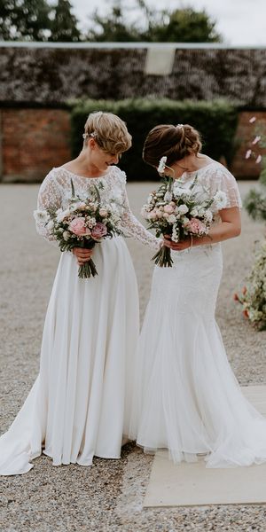 Lesbian couple at Woolas barn wedding with lace and embellished wedding dresses 