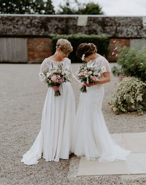 Lesbian couple at Woolas barn wedding with lace and embellished wedding dresses