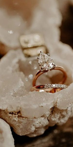 pear shape solitaire diamond engagement ring with gold band with wedding band in crystal ring box