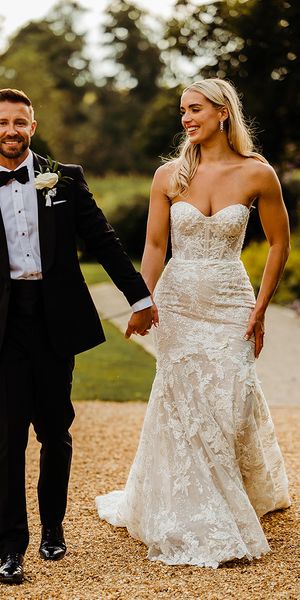 bride-wearing-lace-wedding-dress-with-groom-in-black-tuxedo-for-traditional-wedding