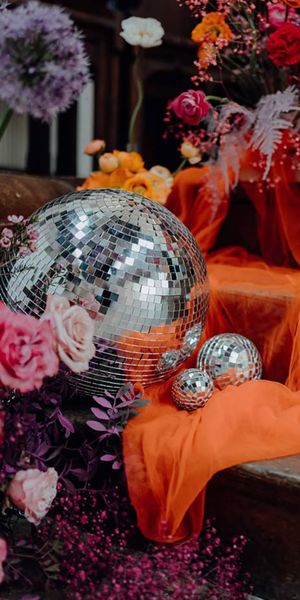 orange and purple wedding colour scheme with disco balls and flowers