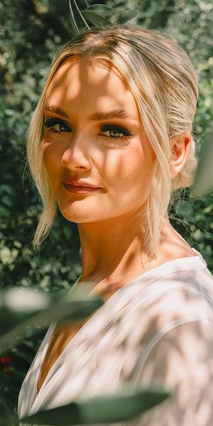 Bride wearing blonde hair in stylish updo with natural wedding makeup with long black eyelashes