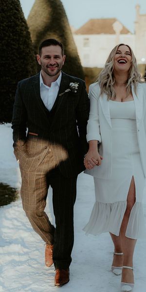 A couple holding hands in the snow for winter wedding